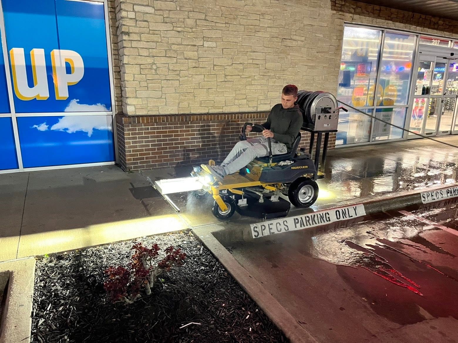 Jordan pressure washing a commercial parking lot at night