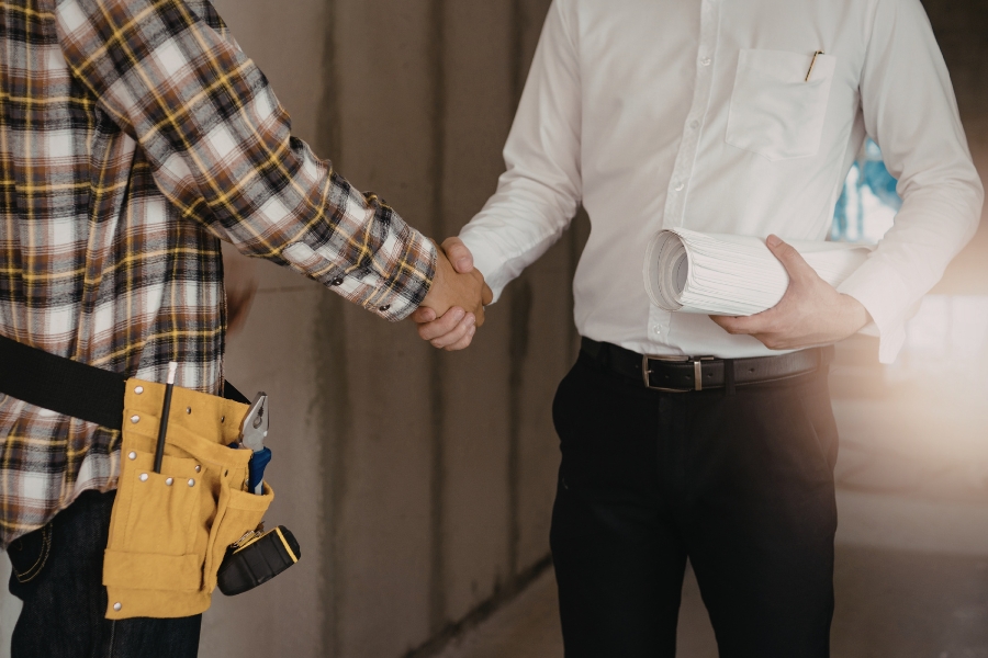 Home service professional shaking hands with homeowner