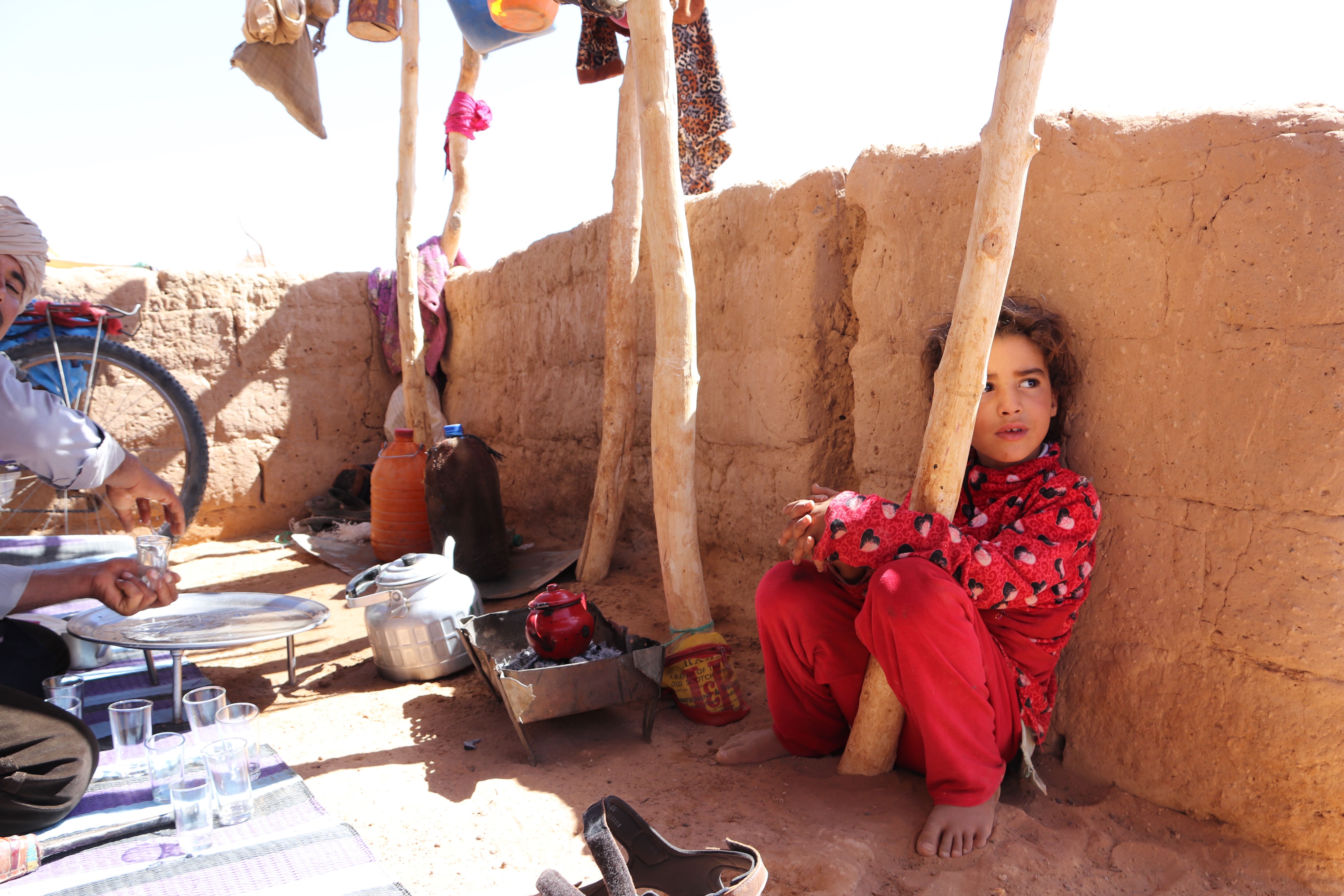 Morocco 2018 - Child Resting by Wooden Post with Tea Set
