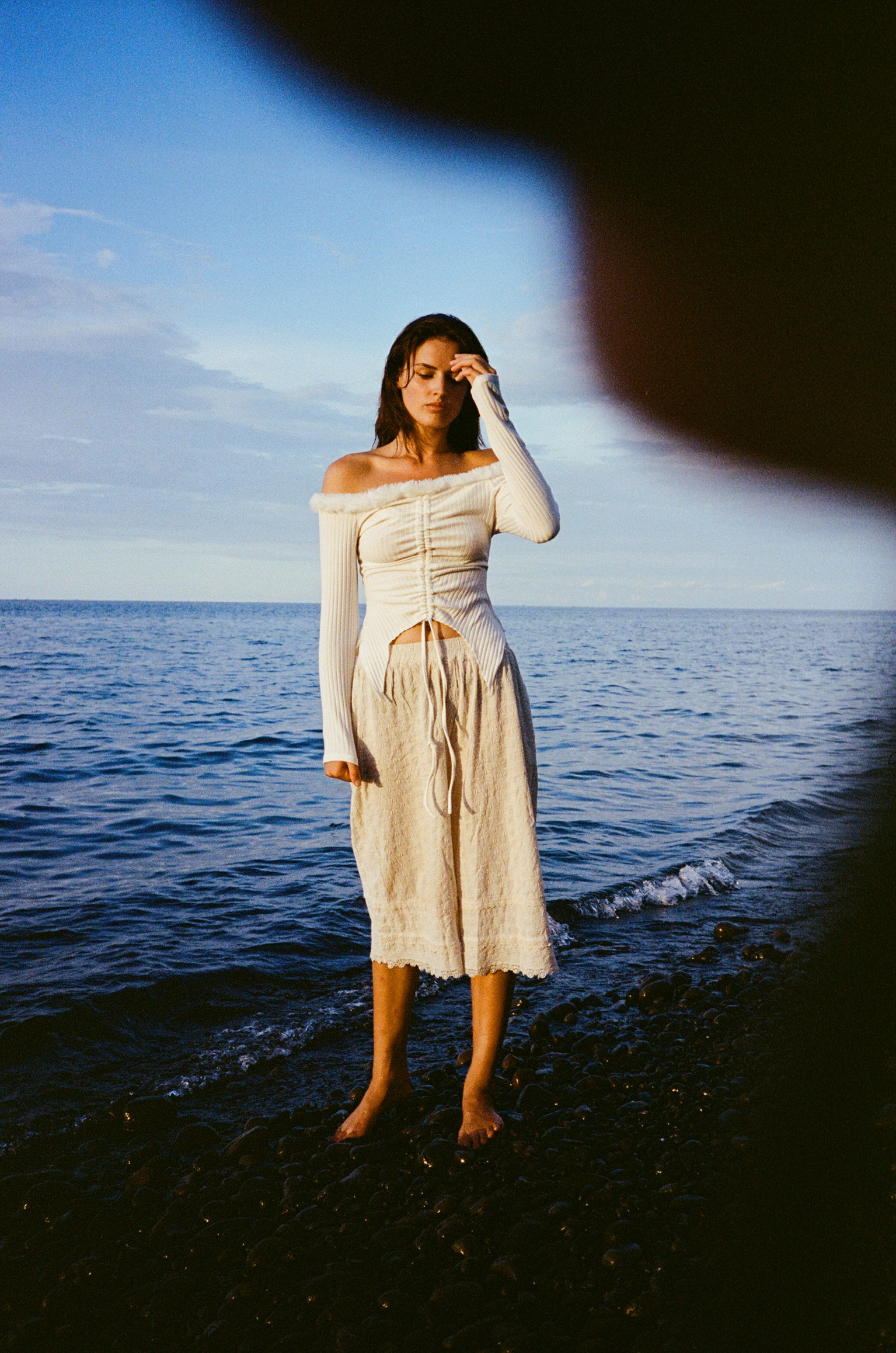 Brother and Sisterhood - Woman in White Dress at Beach with Finger on Forehead
