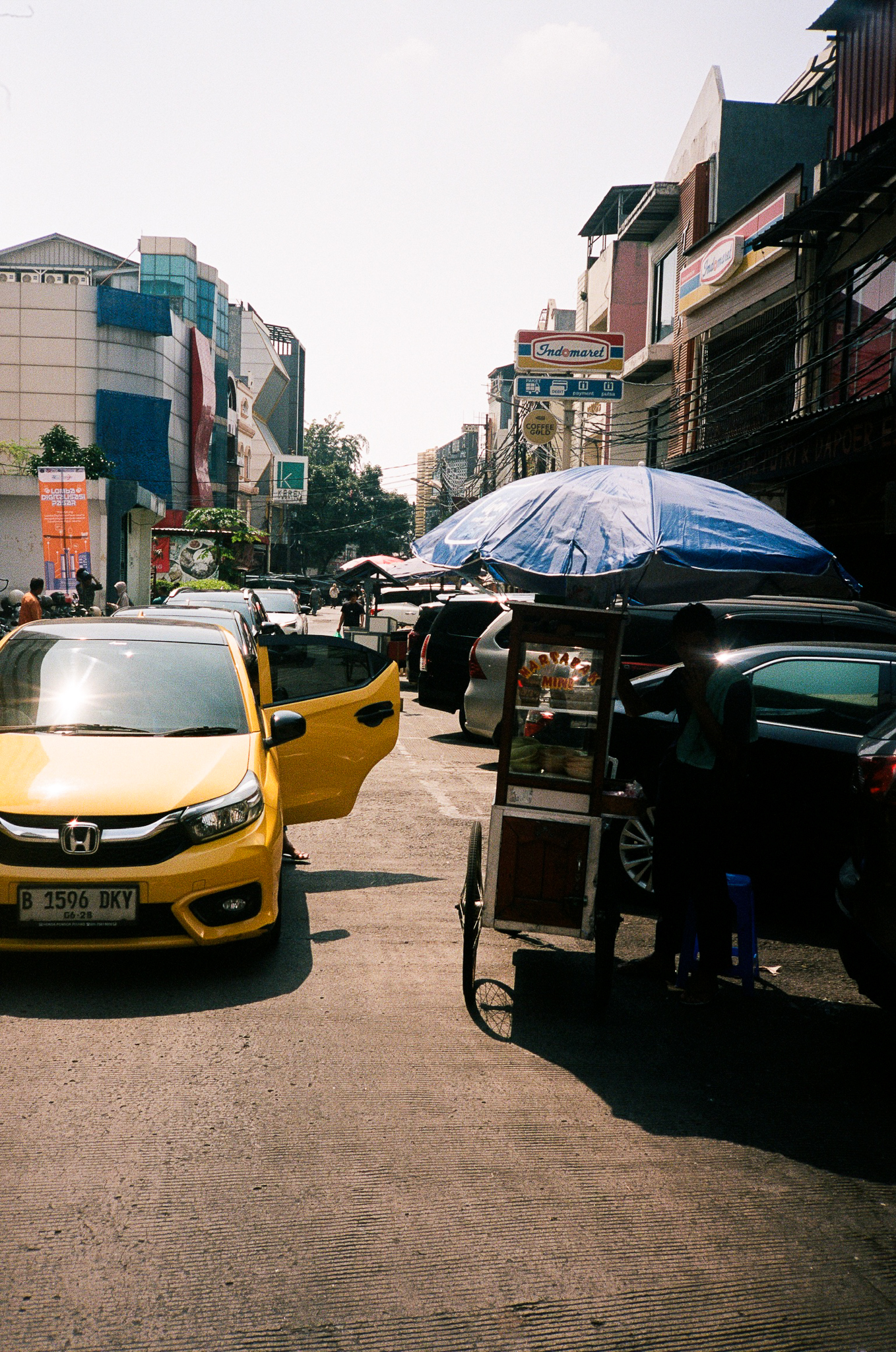 Echoes of Bromo - Street Scene with Yellow Car and Food Cart