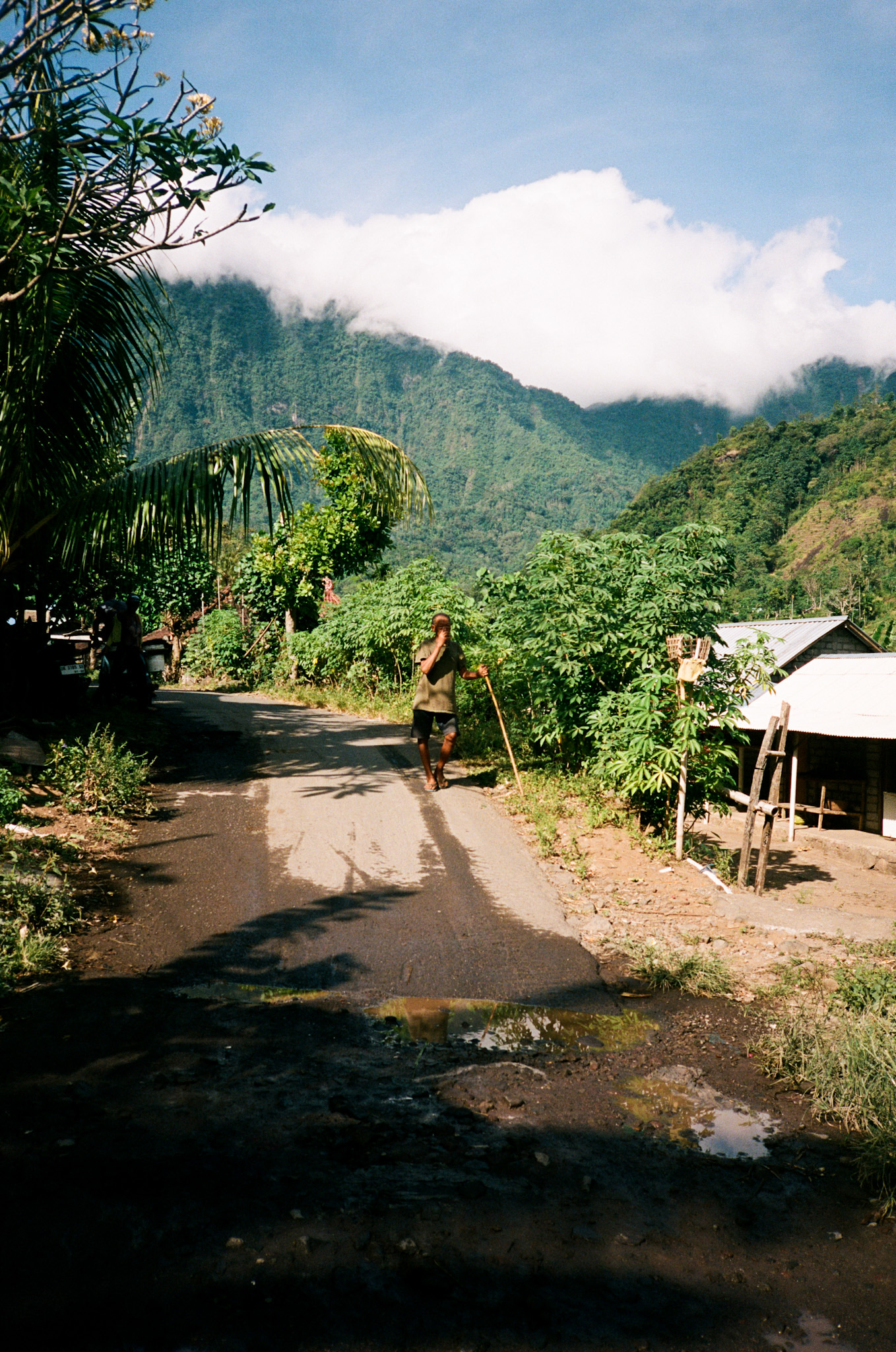 Island of the Gods - Man on Country Road with Misty Mountains
