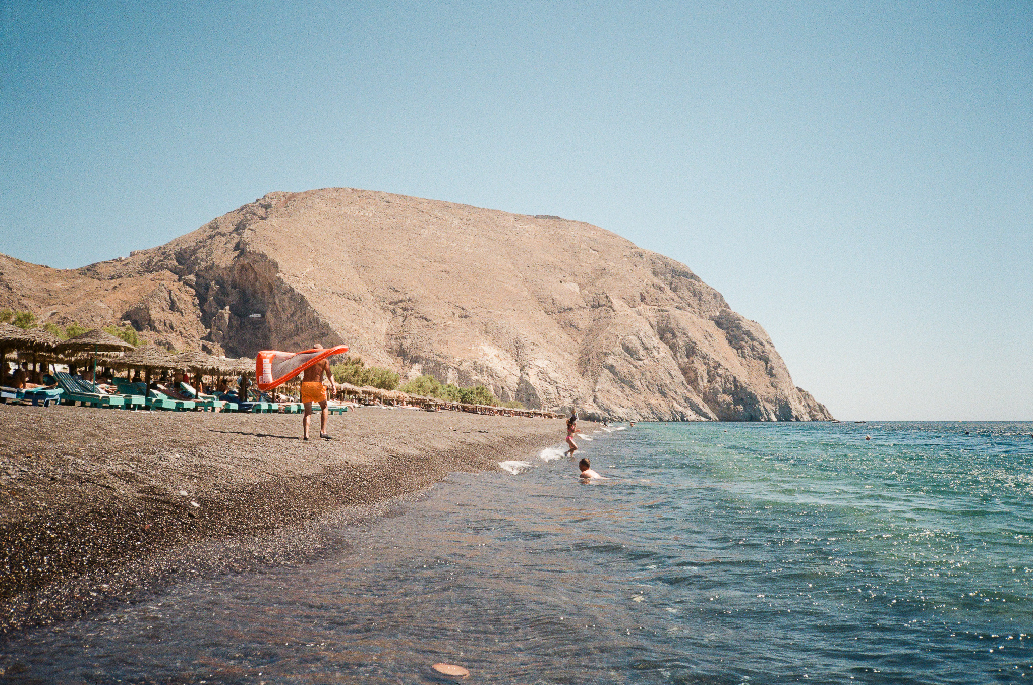 Stories of Greece - Black Sand Beach Man with Orange Float