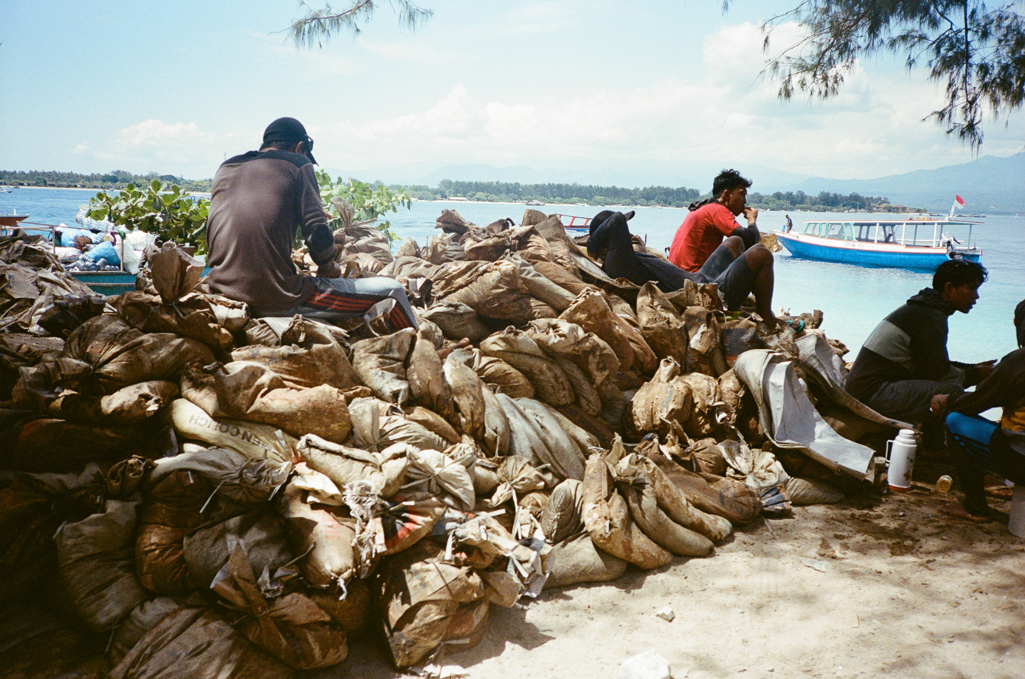 Land of the Sasak - Fishermen Resting on Sacks at Harbor