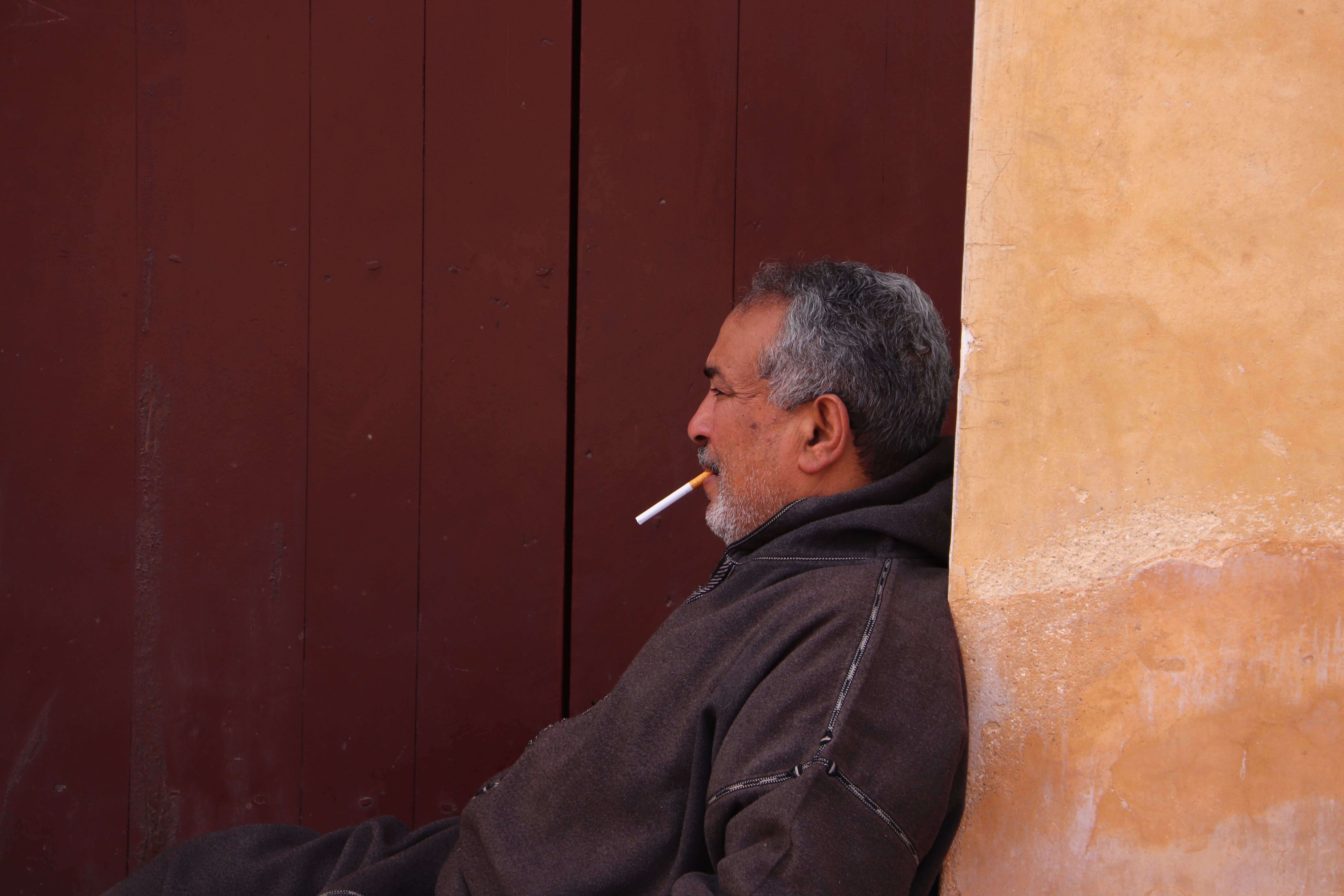 Morocco 2018 - Man Resting Against Wall with Cigarette