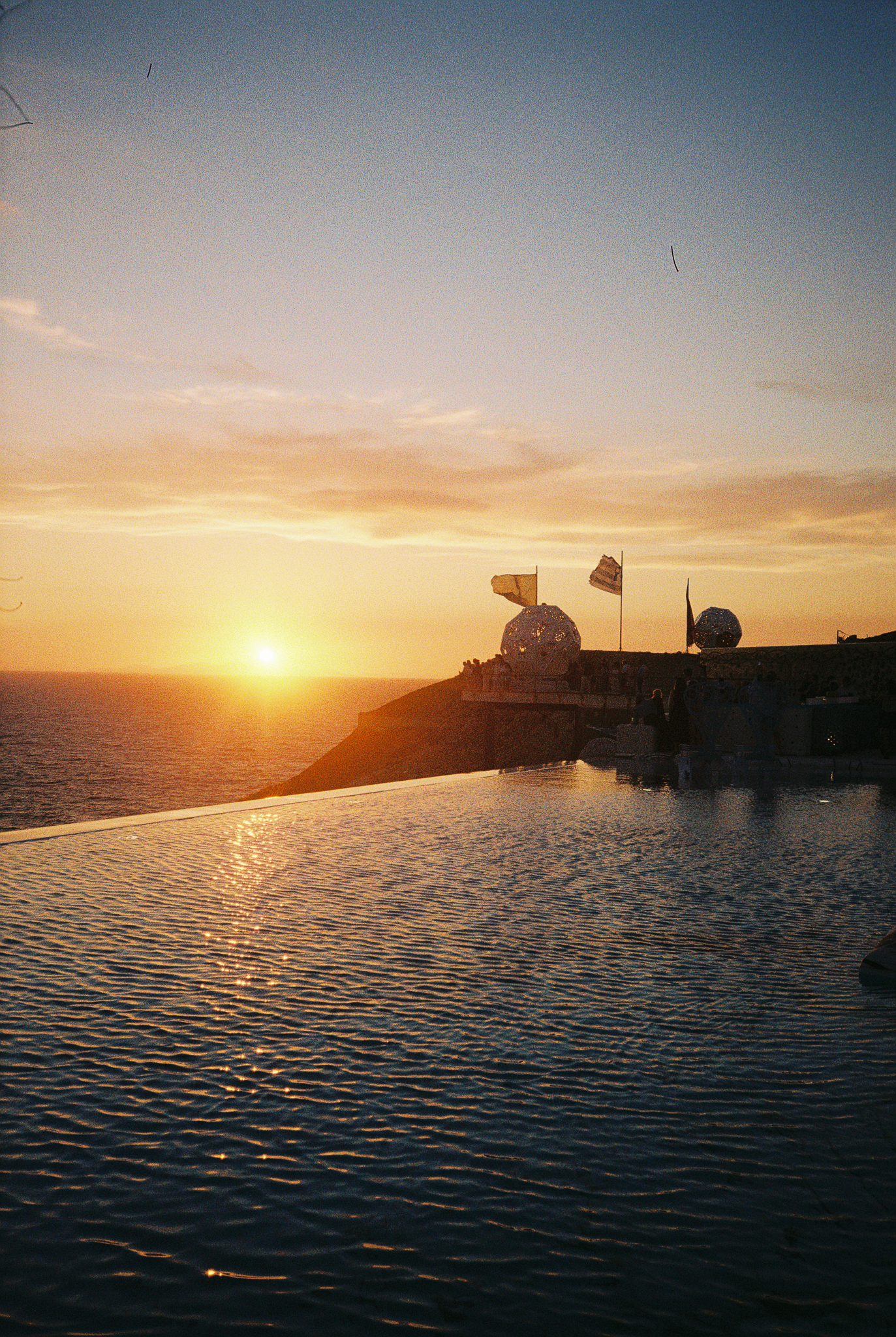 Stories of Greece - Infinity Pool at Sunset with Flags