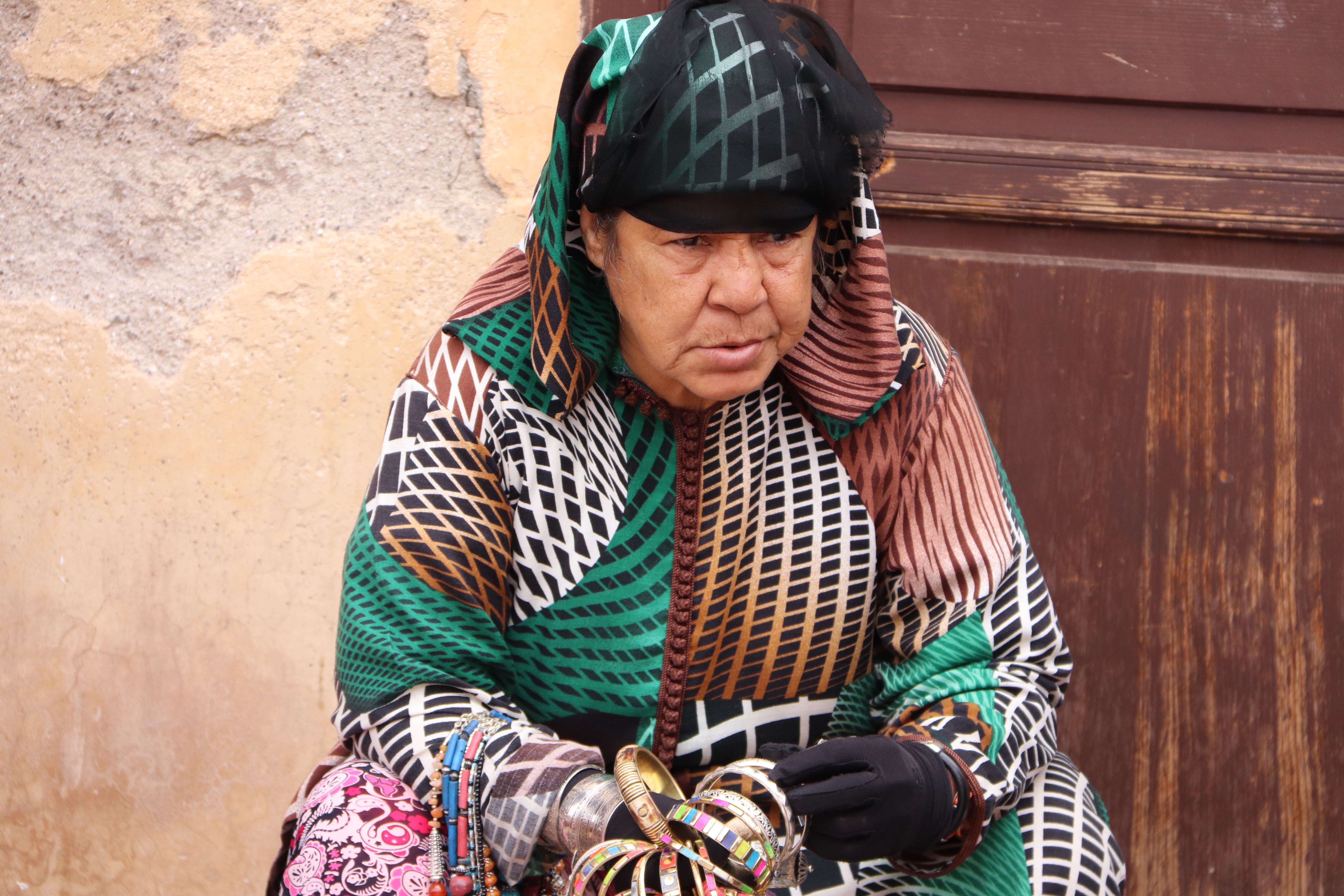 Morocco 2018 - Woman in Traditional Geometric Pattern Dress Selling Bangles