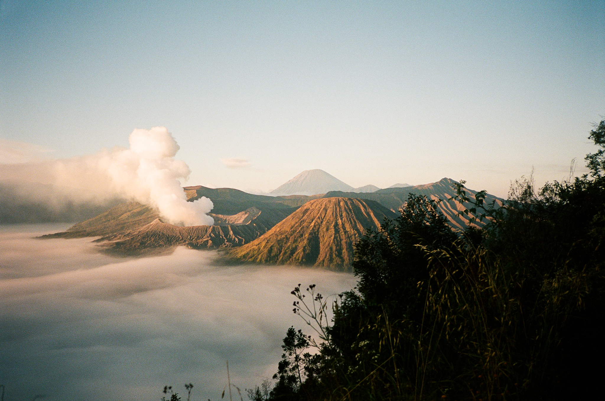Echoes of Bromo - Volcanic Peaks with Smoke Above Sea of Clouds