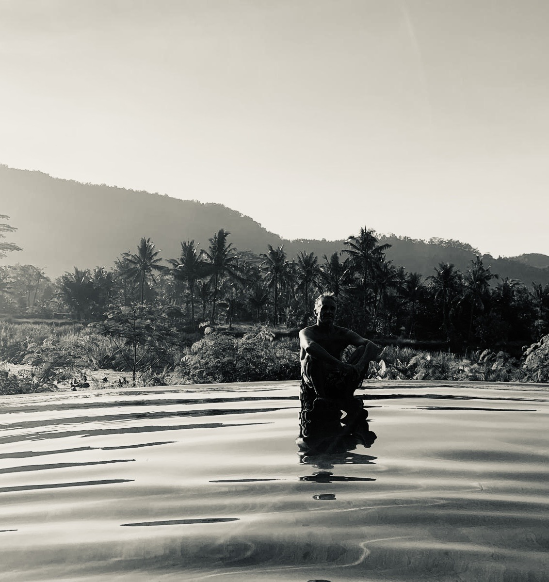 Man sitting in water with reflection