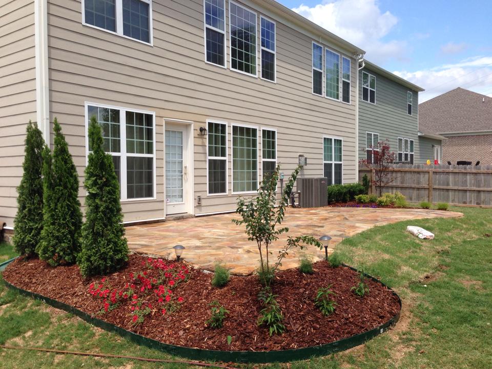 Stone patio with fresh mulch and plantings