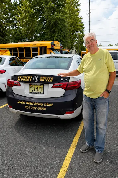 Entcho Hristov standing in front of Golden Wheel Driving School