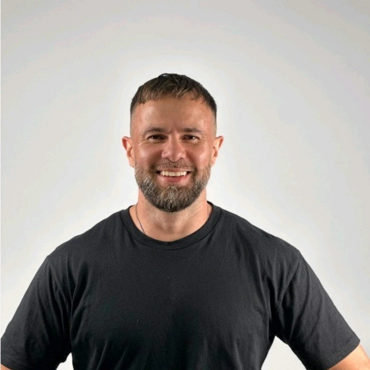 Smiling man in a black t-shirt representing Munyal, an automated booking solutions provider for service businesses, emphasizing revenue recovery from missed calls.