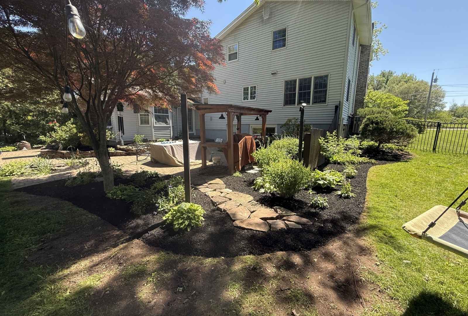 Custom stone walkway and backyard landscape bed transformation