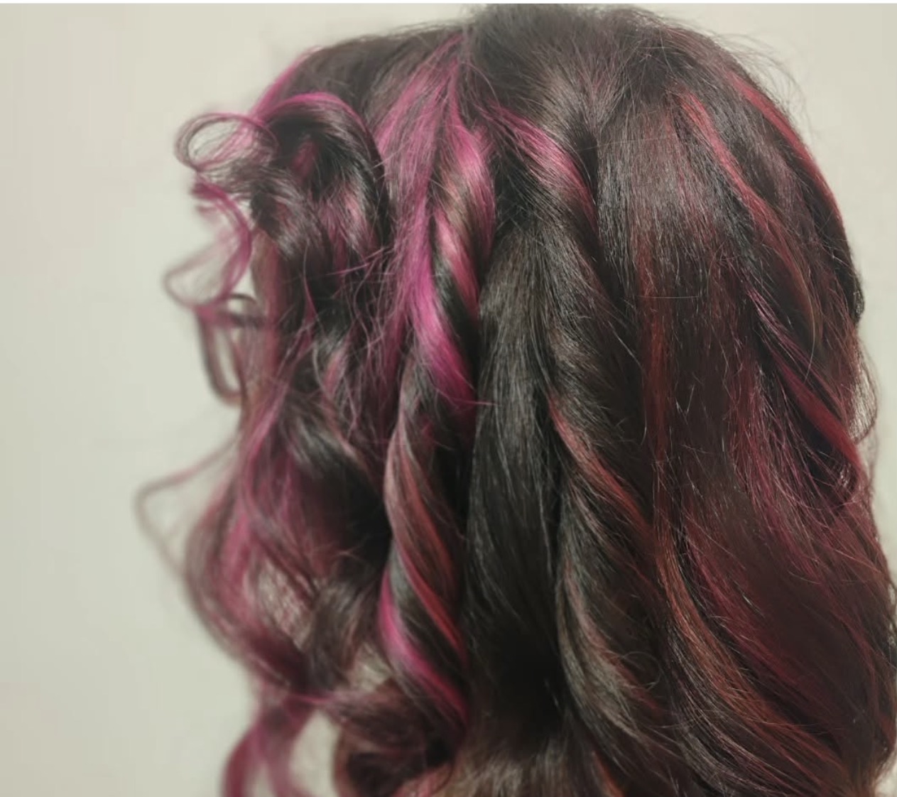 Back view of a custom vivid pink hair color transformation with dimensional waves by Jacksonville stylist