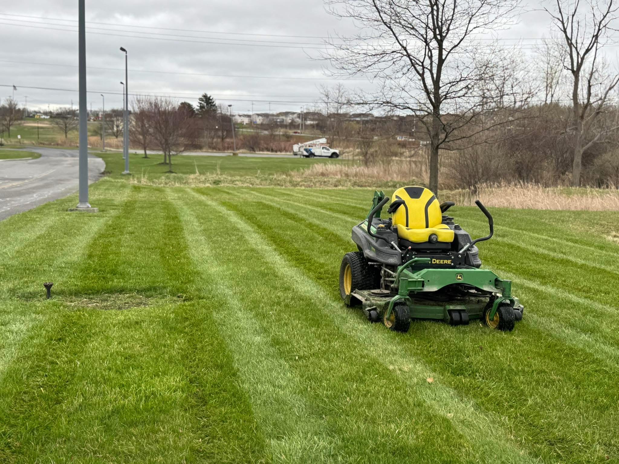 John Deere riding mower on striped lawn