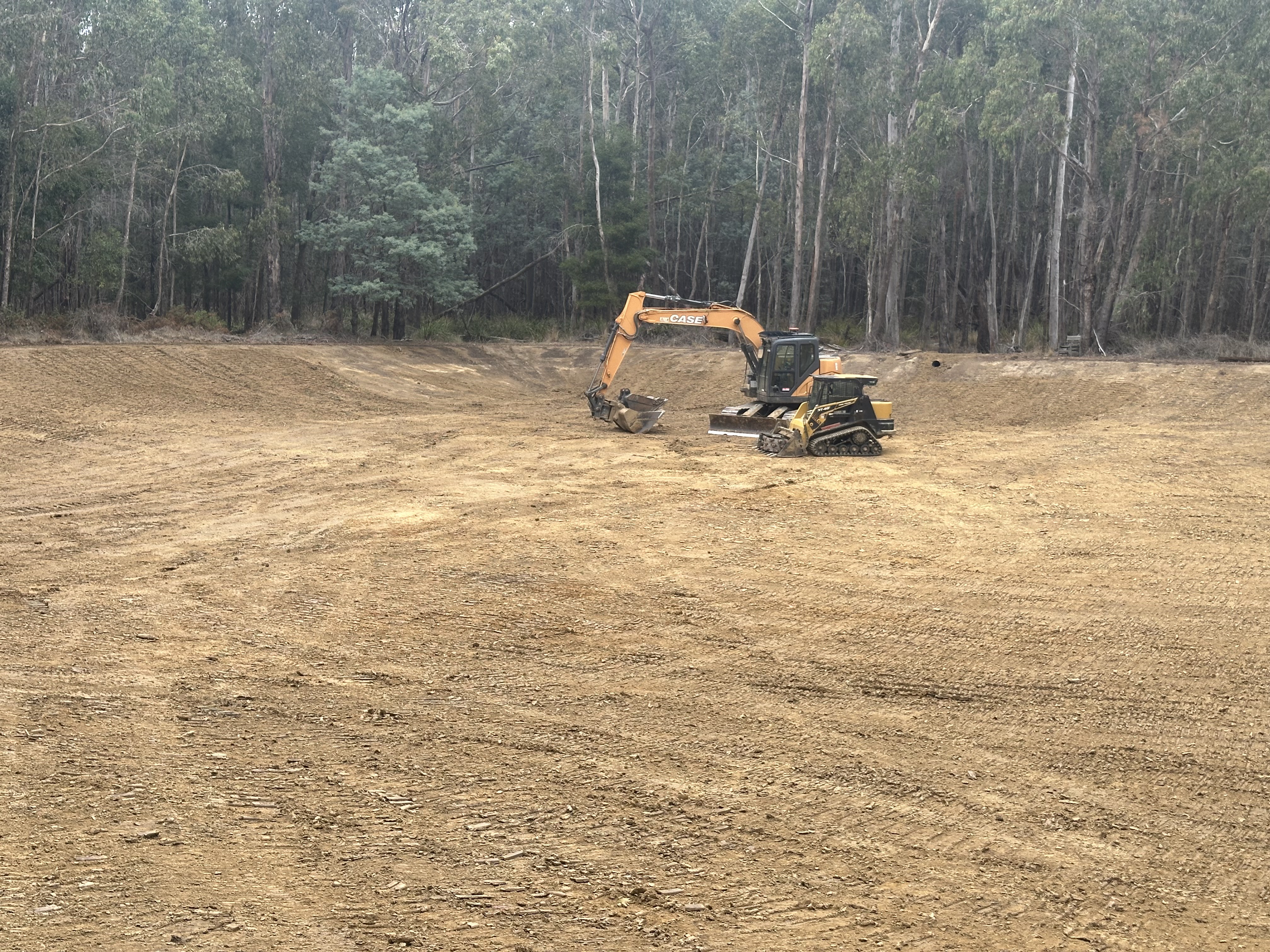 Excavator at work in dark rich soil