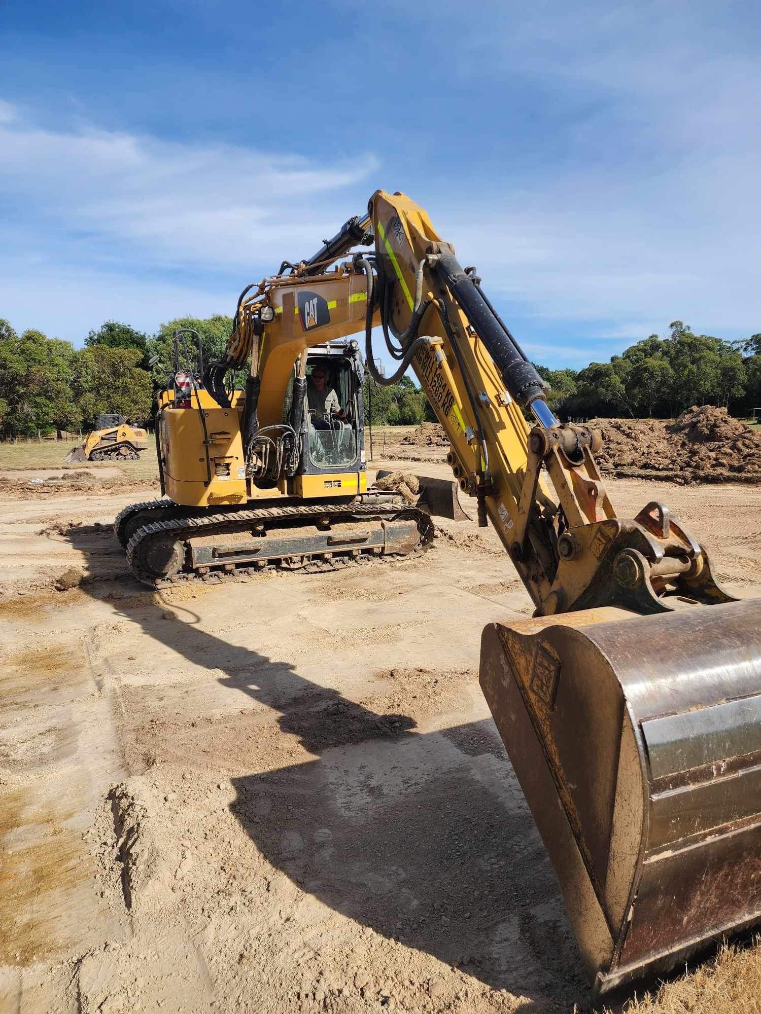 Excavator working on a rural driveway