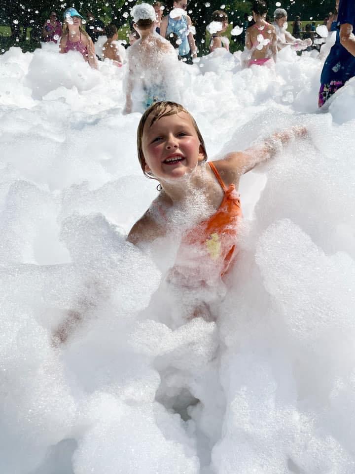 Happy child playing in foam