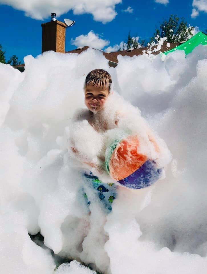 Boy with beach ball in foam