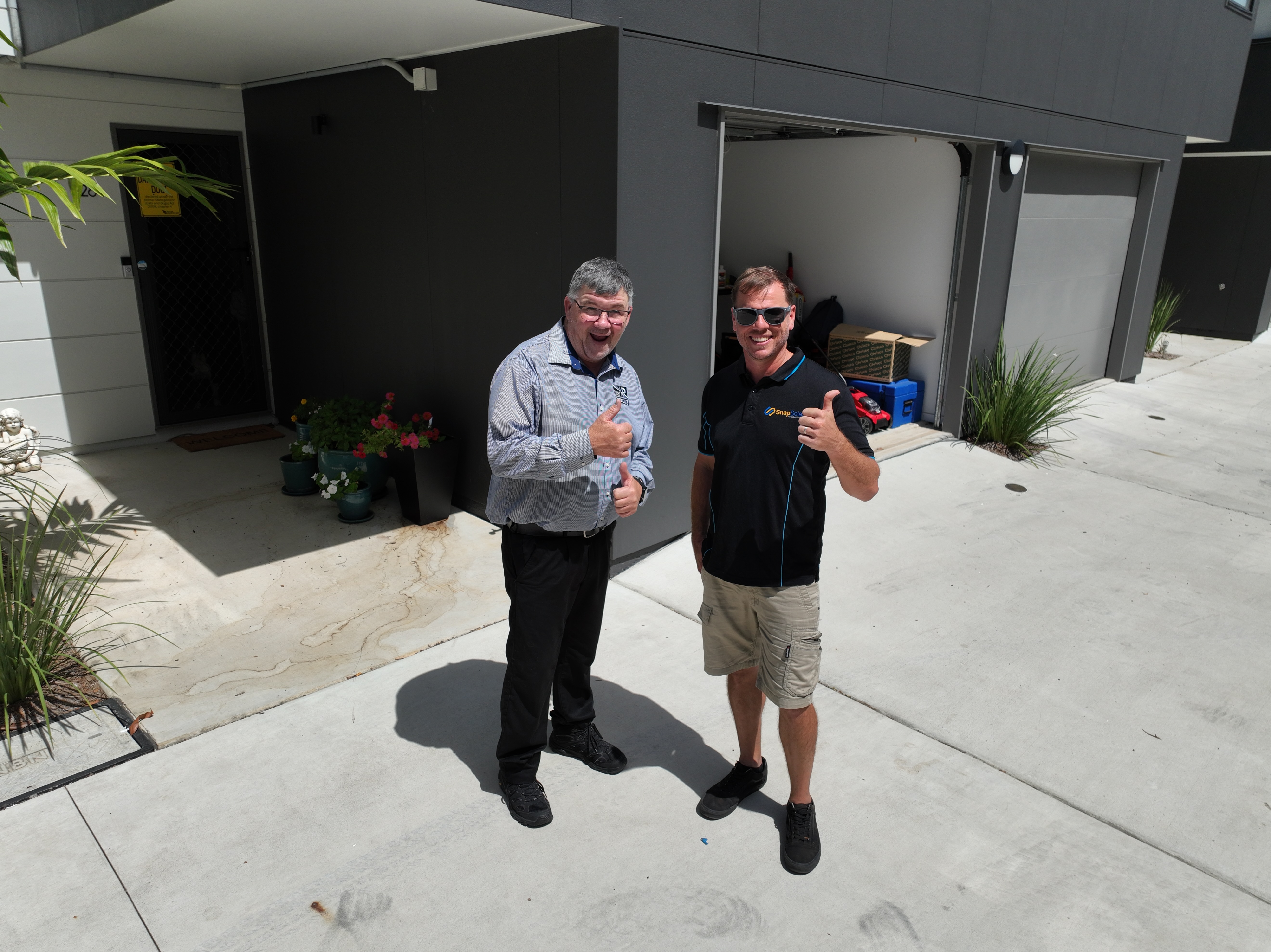 Snap Solar sales consultant Jesse with a happy customer after their solar installation on the Sunshine Coast