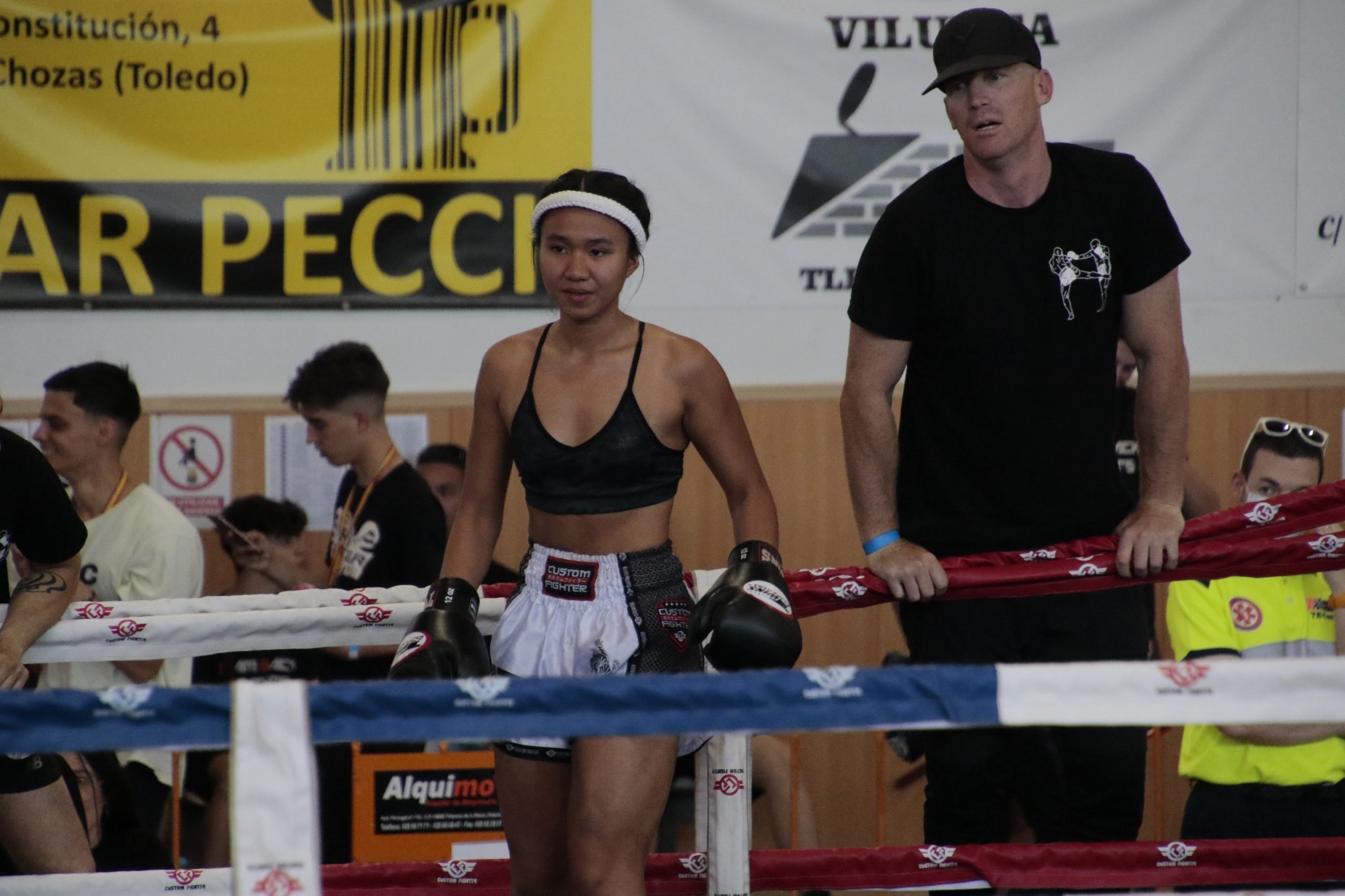 Entrenador profesional golpeando paos de Muay Thai