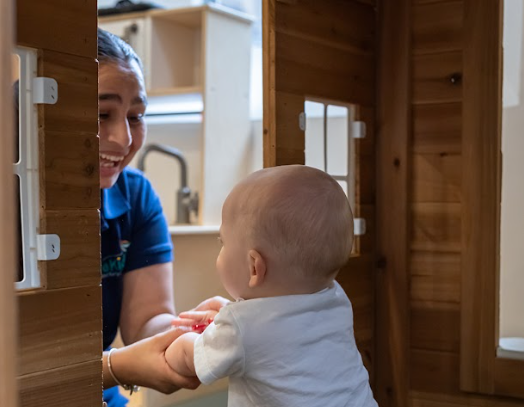 Educator smiling with baby at WeKidz