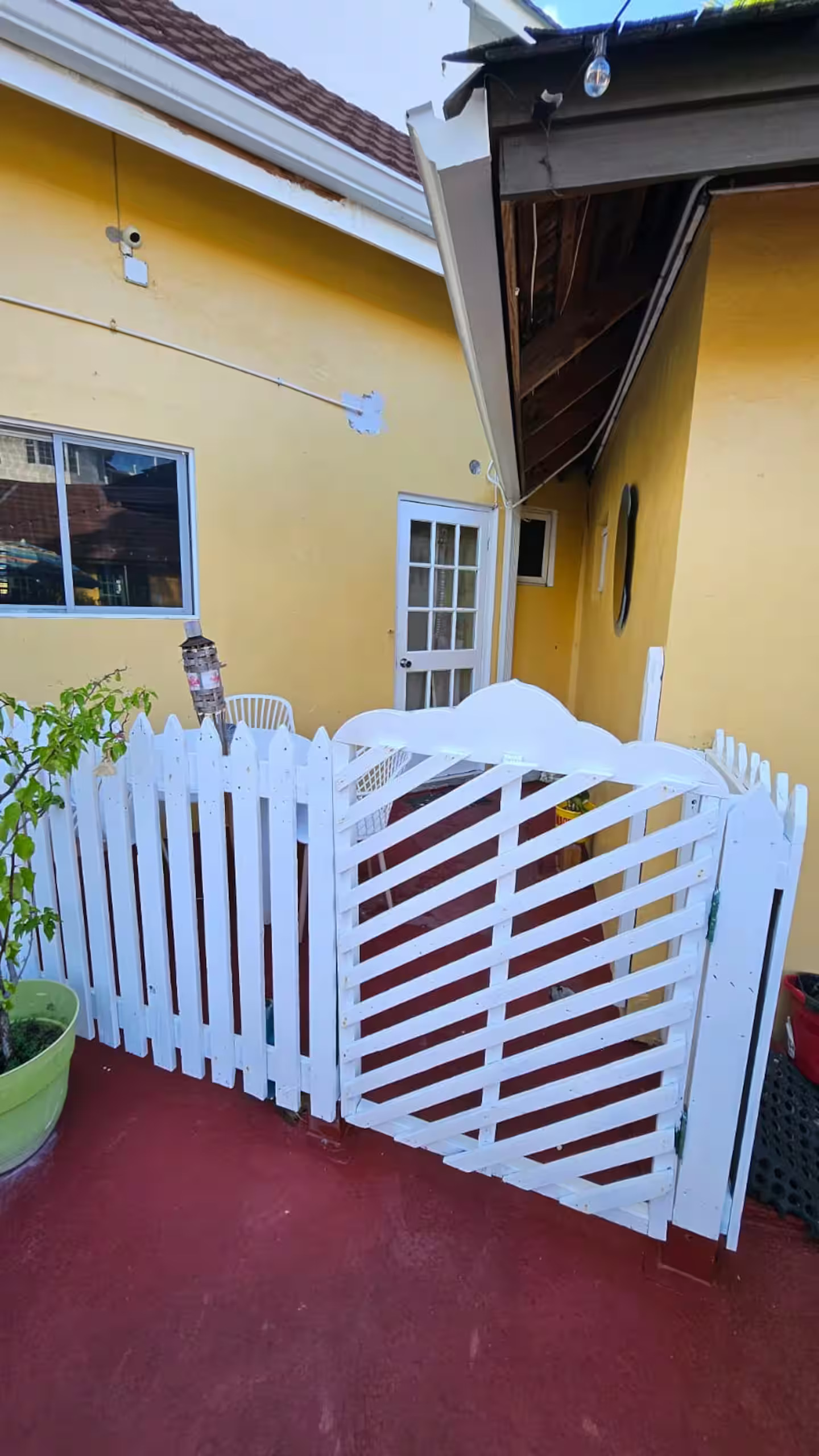 Private Courtyard Terrace with White Picket Gate, Bistro Seating & Tropical Planters