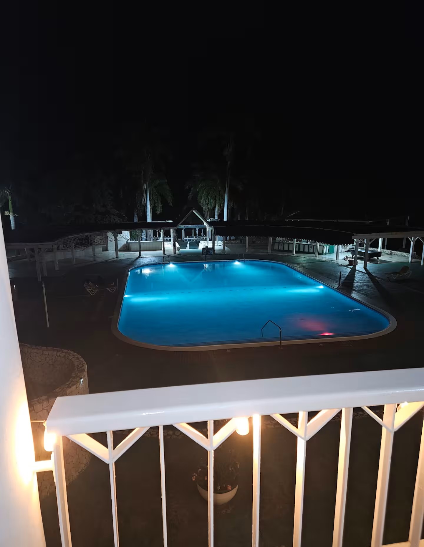 Illuminated Resort Pool at Night Viewed from Private Balcony