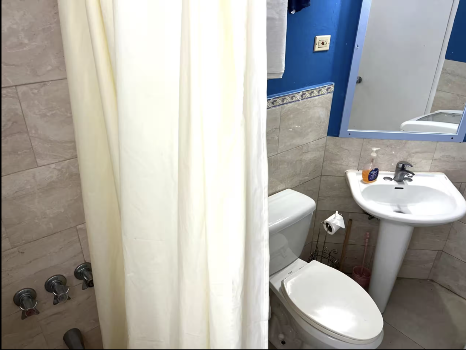 Full Ensuite Bathroom with Pedestal Sink, Blue Accent Wall & Shower