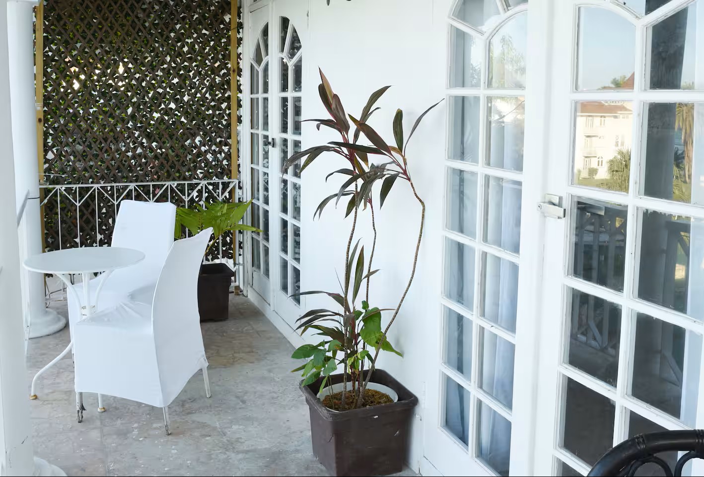 Private Covered Balcony Patio with Bistro Seating & Tropical Greenery