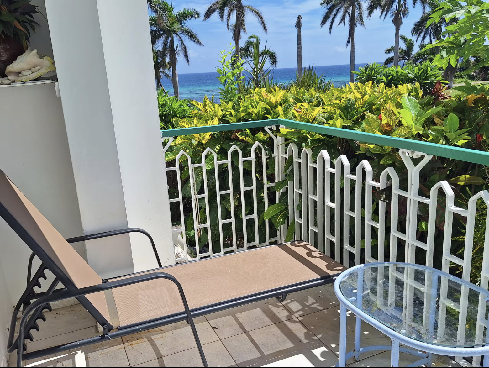Private Sun Terrace Balcony with Lounge Chair, Bistro Glass Table, Tropical Flora & Panoramic Caribbean Sea Views