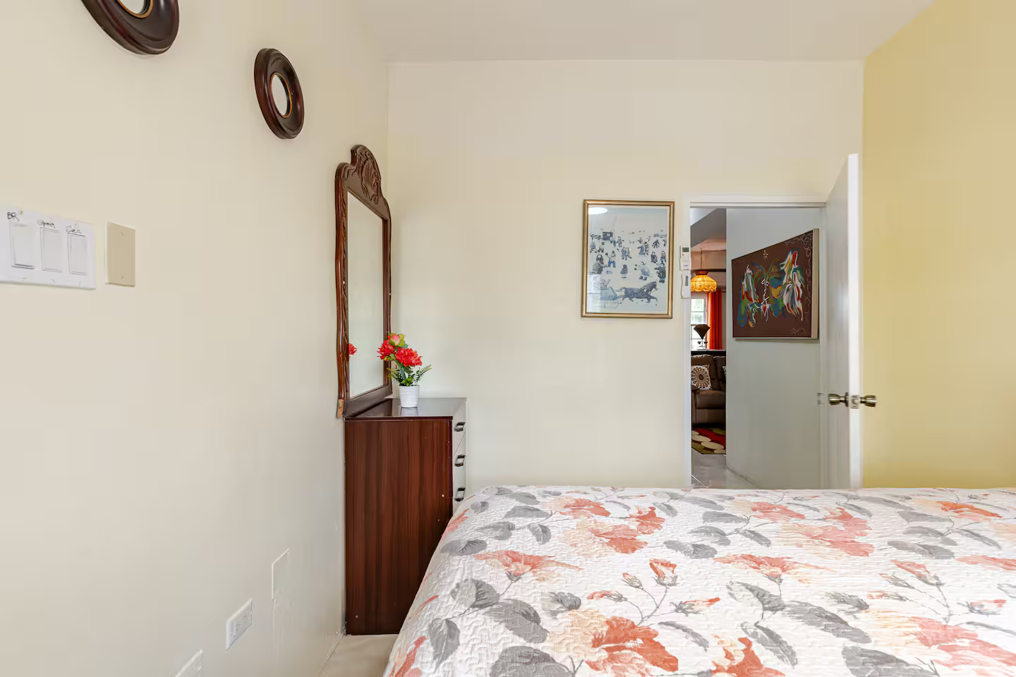 Second Bedroom with Floral Bedding, Vanity Dresser & Hallway Entrance View