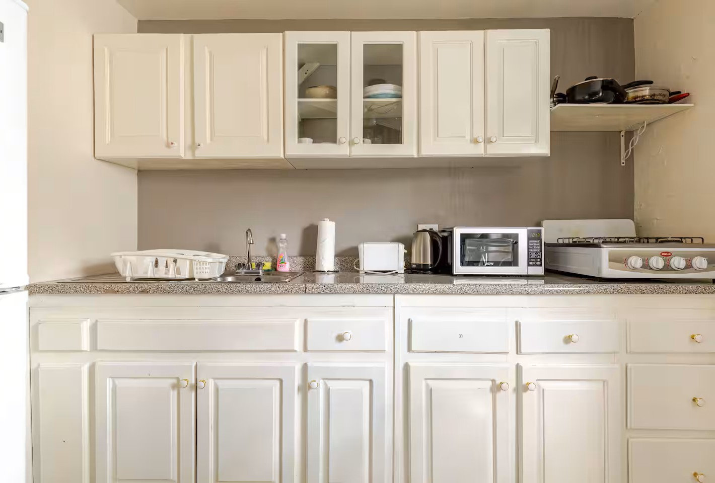 Fully Equipped Kitchenette with White Cabinetry & Gas Cooktop