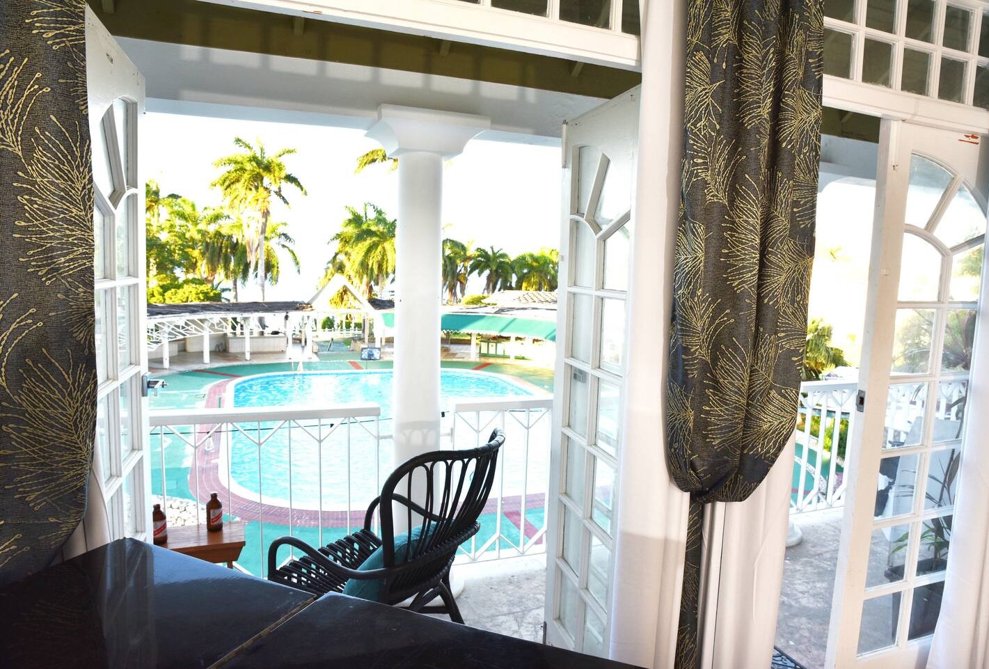 French Doors Opening to Private Balcony with Resort Pool & Palm Views