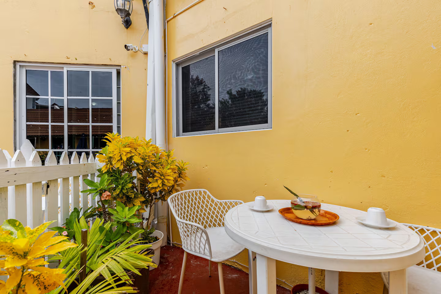 Private Courtyard Patio Terrace with Bistro Table, Lush Tropical Plants & Picket Fence