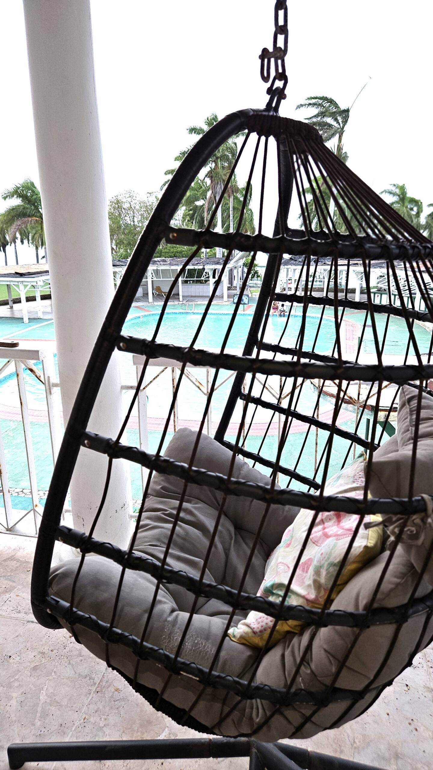 Balcony Hanging Egg Chair Overlooking the Swimming Pool
