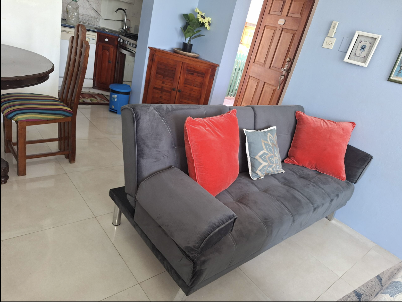 Plush Charcoal Velvet Sleeper Sofa with Coral Pillows & Dining Area View