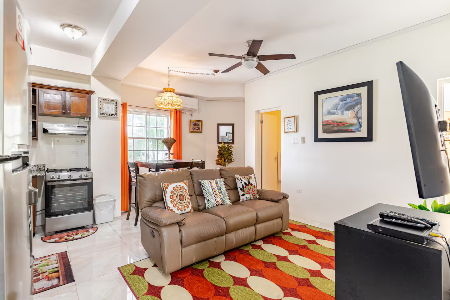 Spacious Living Salon with Ceiling Fan, Leather Recliner Sofa, Dining Set & Gas Range