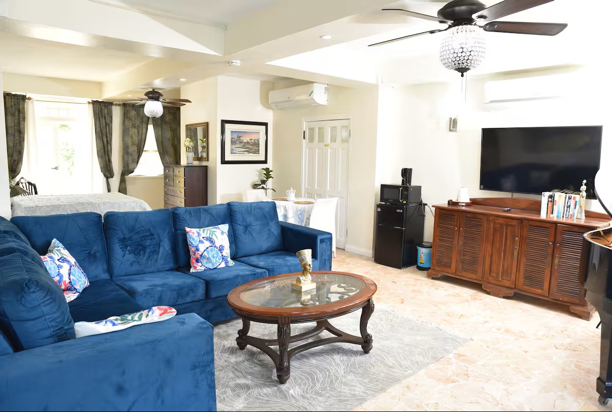 Open-Concept Living Room with Blue Velvet Sectional, Smart TV & AC