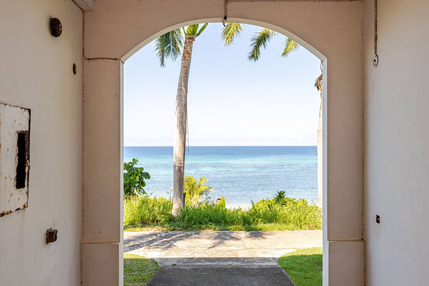 Architectural Estate Archway Framing the Turquoise Ocean & Coconut Palms