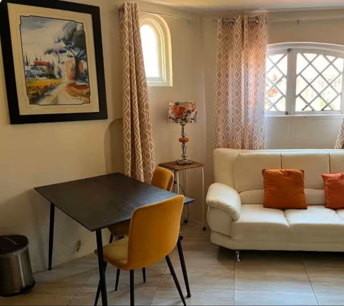 Cozy Sitting Lounge with White Sofa, Accent Cushions & Scenic Landscape Art