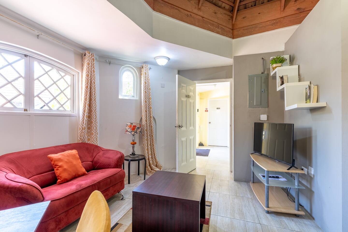 Living Salon with Cathedral Wood Ceiling, Plush Red Sofa & Smart TV