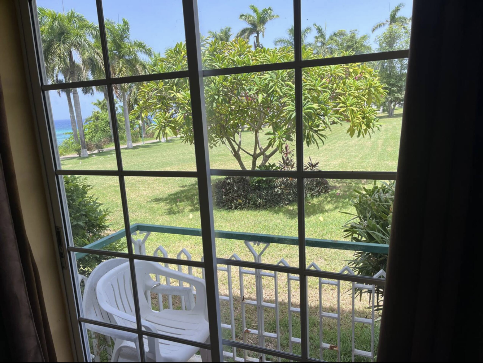 Bedroom Window View Looking Out to Flowering Trees, Lush Lawn & Glimpse of the Caribbean Sea