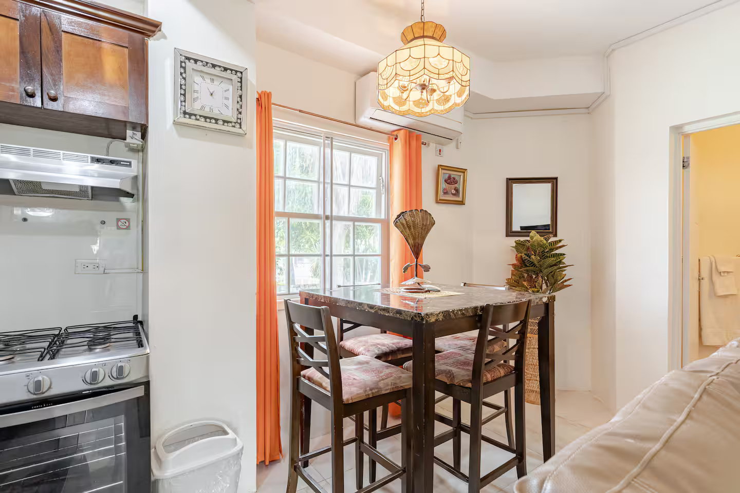 Intimate Dining Nook with High-Top Marble Table, Stained Glass Chandelier & Split A/C