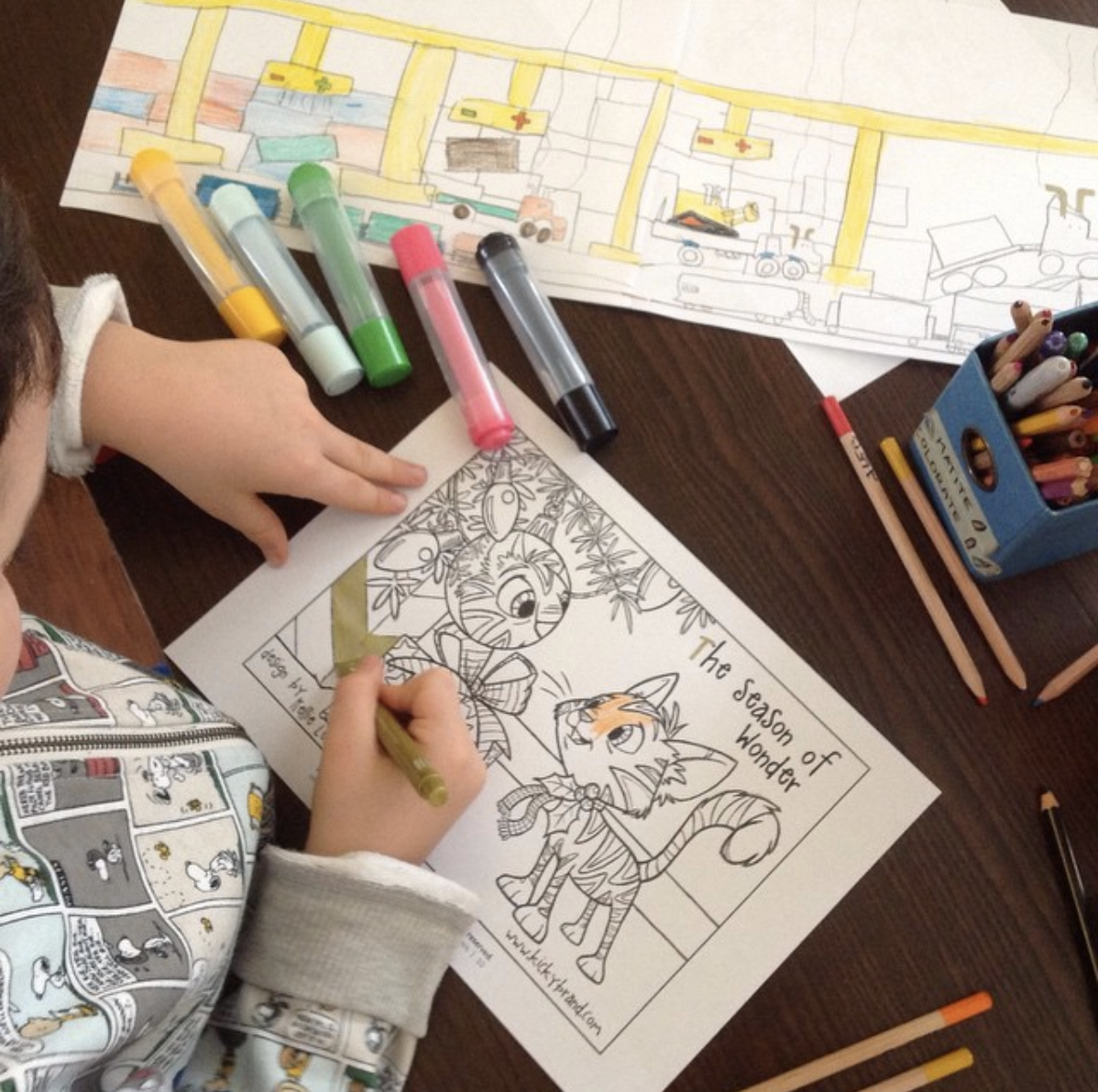 Child coloring a cat and ornaments page