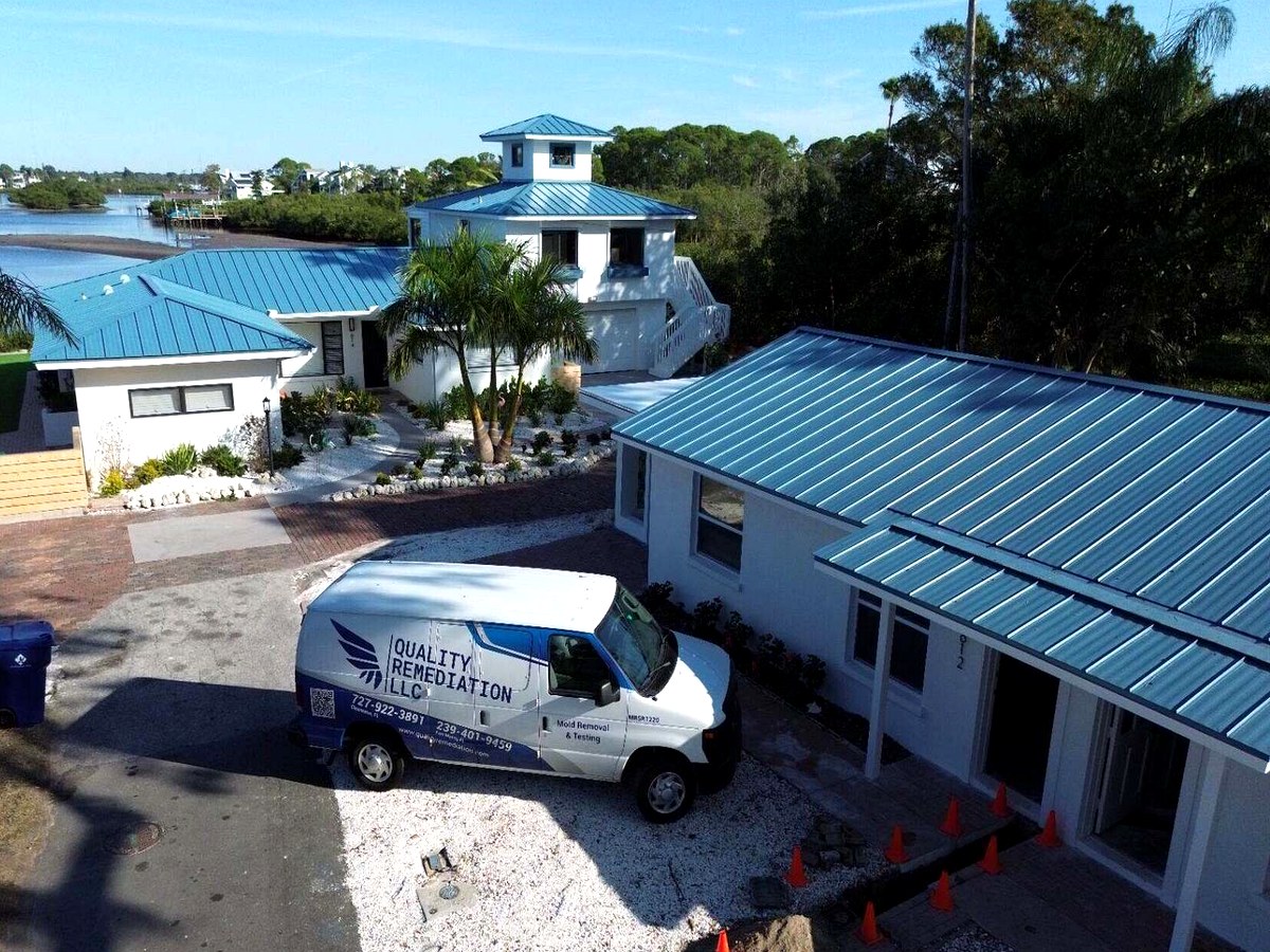 Quality Remediation USA branded service van at a waterfront Florida property.
