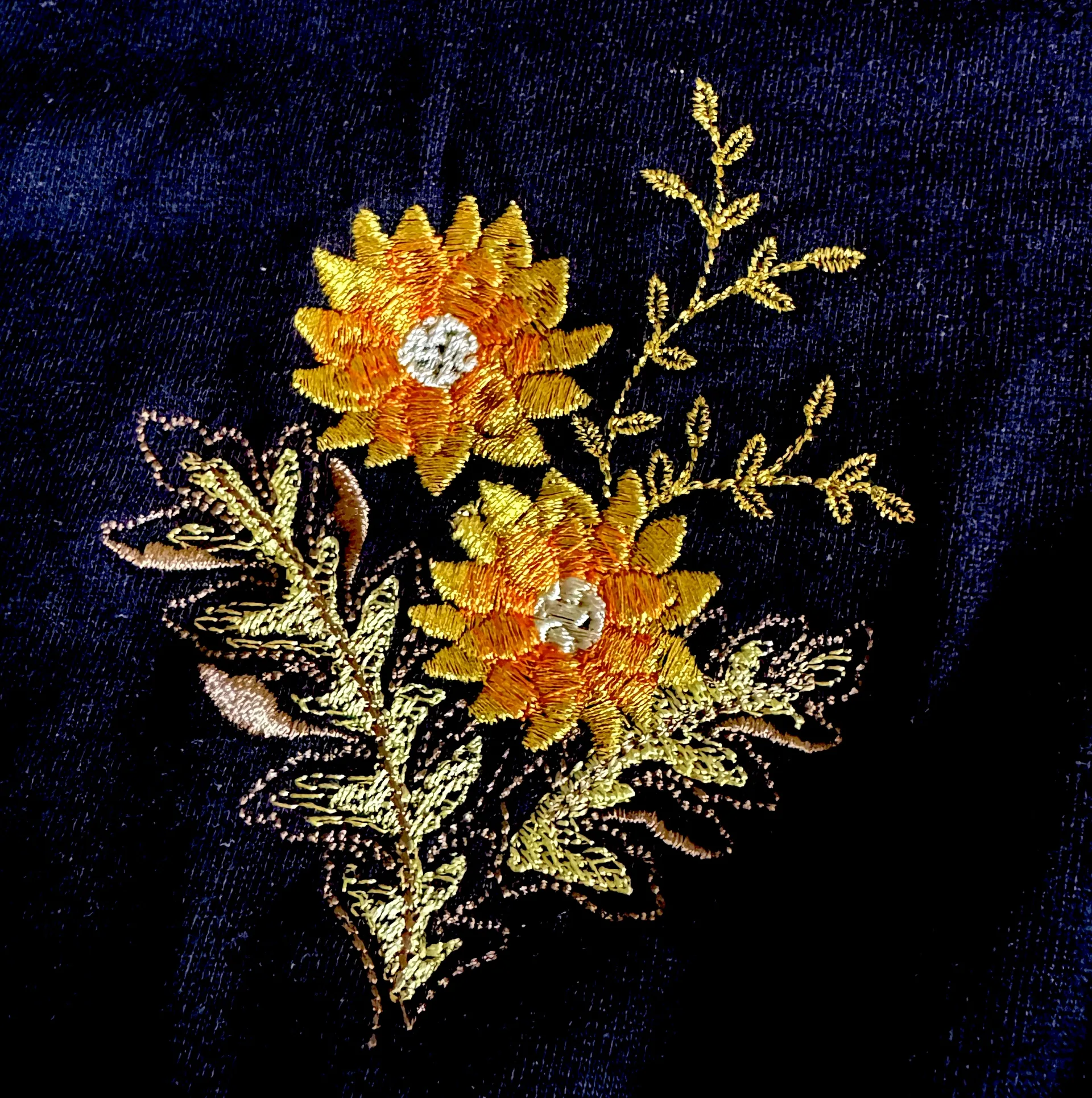 Detailed sunflower embroidery on navy fabric