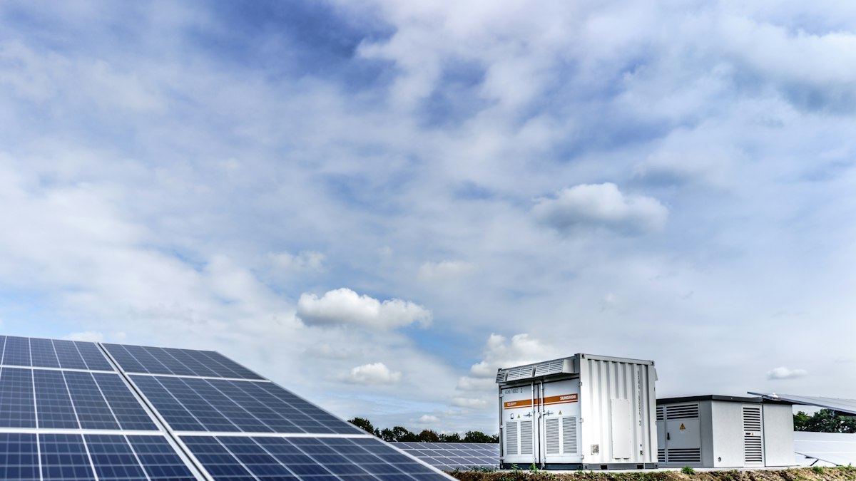 Ground-mounted photovoltaic plant with central inverters under a blue sky