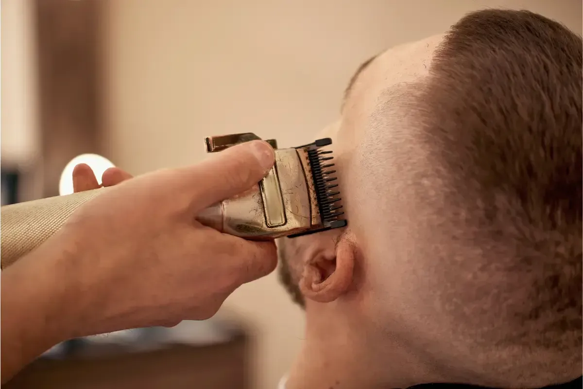 Barber using clippers on a fade haircut