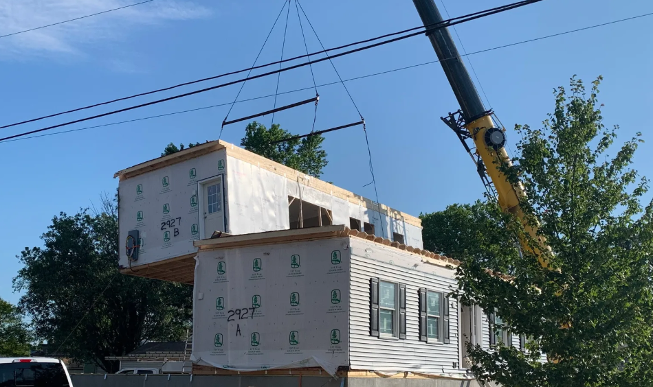 Crane lifting a modular home section